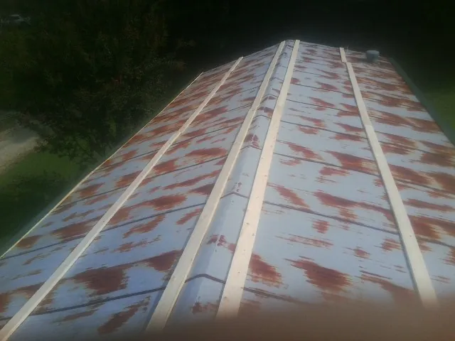 Rusted metal roof panels with new wood purlins before replacement — Storm Damage Roof Repair in Saint Anthony by Roofing Brothers